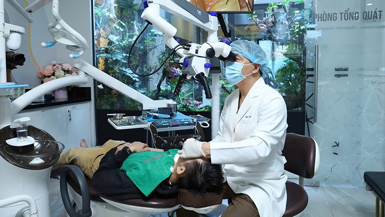 Bác sĩ Nha Khoa Phương Thành đang thực hiện điều trị bằng kính hiển vi tại phòng tổng quát, đảm bảo độ chính xác và an toàn cao